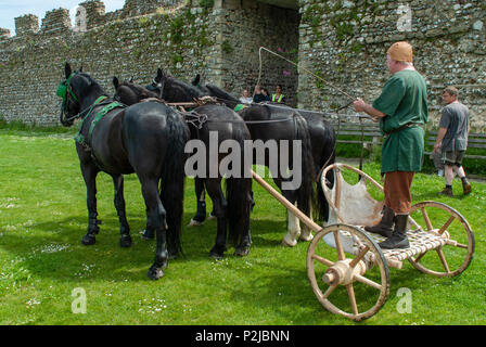 Römisch-antiken Britischen - 4 schwarze Pferd Kampf wagen Demonstration. Lebendige Geschichte Gruppe an Portchester Castle, Hampshire, Großbritannien Stockfoto