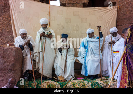 Ältere Mitglieder der Äthiopischen Orthodoxen Kirche sammeln bei einem von Lalibela in Felsen gehauenen Kirchen. Stockfoto