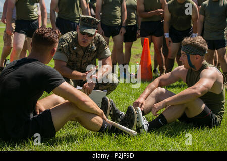 Kapitän Jason Smith erklärt das Konzept von "Aide Liesg' Während der Camp Hansen Highland Games in Okinawa, Japan, Sept. 30, 2016. Das Ziel dieses Spiels ist es, den Gegner aus dem Boden zu heben und ziehen Sie gleichzeitig gegeneinander. Die Veranstaltung gemischt schottischen und keltischen Kultur mit Wettbewerb zwischen unterstützende Einheiten auf Lager Hansen. Die Teilnehmer der Spiele in Stein konkurrierten, sheaf Toss und andere Versuche der Stärke. Smith ist der Zentrale und Service Company Commander III Marine Expeditionary Force Headquarters Group, III MEF. (U.S. Marine Corps Foto von Cpl. Steven Tran/Freigegeben) Stockfoto