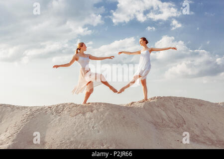 Zwei Tänzer tanzen in der Wüste im Sand, die Sie berühren sich gegenseitig die Füße. Stockfoto