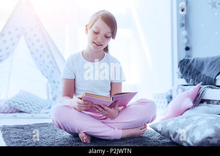 Fleißige Schülerin neues Buch zu Hause genießen Stockfoto