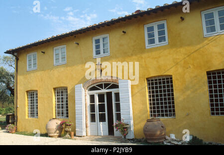 Die Außenseite des Gelben toskanische Villa mit weissen Fensterläden auf die Hälfte gemalt - verglaste Doppeltüren Stockfoto