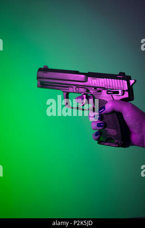 Woman's Hand mit automatische Pistole Gewehr. Stockfoto