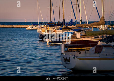 Segelboote Rest friedlich an ihrem Liegeplatz wie die Sonne auf Burnham Hafen, Chicago Lakefront setzt. Stockfoto
