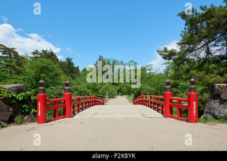 Hohe Aufnahme von Takaokahashi Brücke von Blumen und Grün in Hirosaki Park, in Hirosaki, Japan eingerahmt. Stockfoto