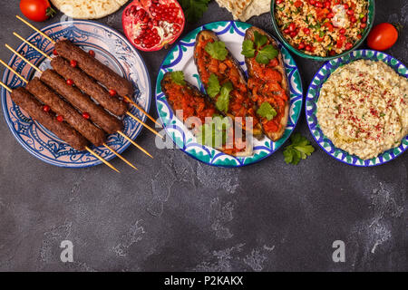 Klassische Kebabs, tabbouleh Salat, Baba ganush und gebackene Auberginen mit Soße. Traditionelle orientalische oder arabische Gericht. Ansicht von oben. Stockfoto