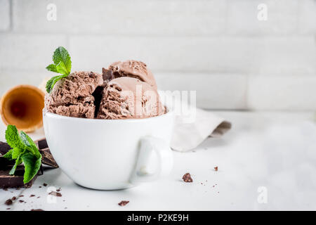 Hausgemachte Schokolade Eis serviert mit frischer Minze, dunkle Schokolade und Waffel Eistüten, weißem Marmor Background Copy space Stockfoto