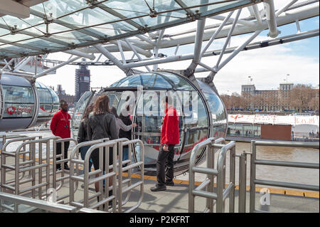 Passagiere queuing Bord eine Kapsel des London Eye, einem beliebten Riesenrad, ein Wahrzeichen von London, durch die Themse in London. Stockfoto