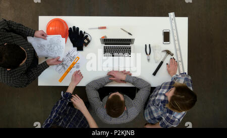Ernsthafte Manager in Gläsern am Laptop auf der Suche und im Gespräch mit seinem Team Stockfoto
