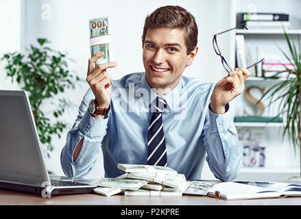 Erfolgreicher Geschäftsmann nimmt seine Brille und mit Geld. Foto junger Mann bei der Arbeit im Büro. Business Konzept Stockfoto