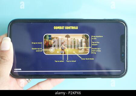 Eine weibliche spielen die Nummer 1 oben Einspielergebnis mobile Game Fortnite Battle Royale auf einem iPhone X Stockfoto