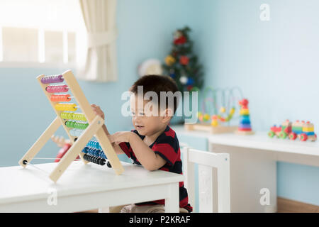 Asiatische Kleinkind baby boy lernt zu zählen. Niedliche Kind spielen mit Abacus Spielzeug. Little boy Spaß Zuhause zu Hause. Pädagogisches Konzept für Kleinkind bab Stockfoto