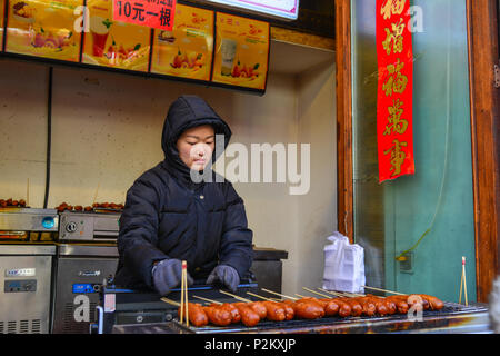 Harbin, China - Feb 22, 2018. Ein Anbieter Verkauf von Speisen auf der Walking Street in Harbin, China. Harbin ist die größte Stadt in der nordöstlichen Region von China. Stockfoto