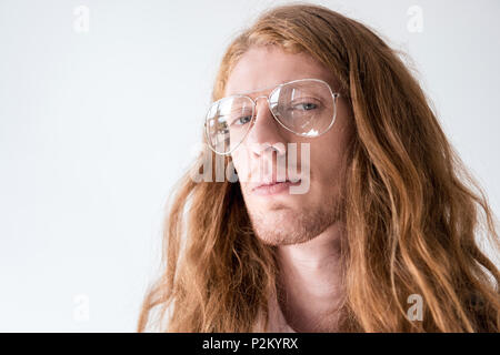 Portrait von stattlicher Mann mit lockigem Ingwer Haare und eine Brille mit Kamera isoliert auf weißem Stockfoto