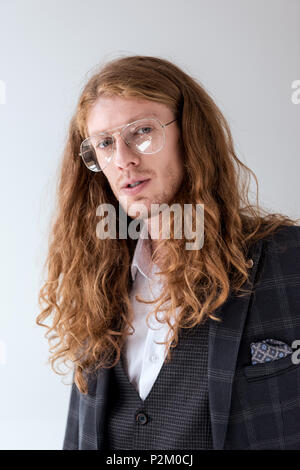 Portrait von stilvollen Geschäftsmann mit lockigem Haar an Kamera suchen Stockfoto