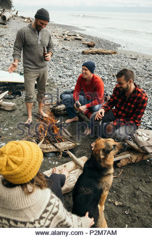 Freunde Biere genießen, entspannen am Lagerfeuer auf robusten Strand