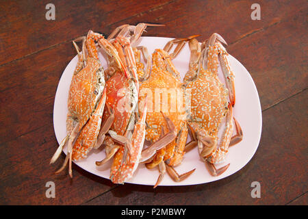 Gekochte Krabben in Teller auf hölzernen Tisch Stockfoto