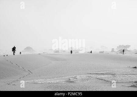 SOSSUSVLEI, NAMIBIA - 15. MAI 2018; Touristen über Dünen während Sand storm Ankunft in Schwarzweiß. Stockfoto