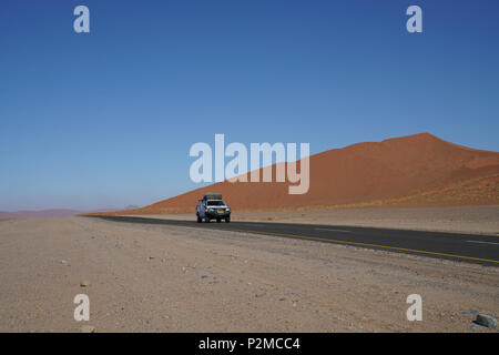 Reisende im Fahrzeug Straße durch Sossusvlei Dünen in Namibia. Stockfoto