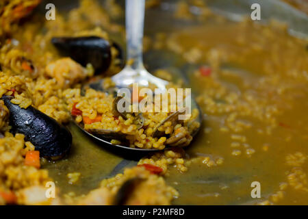 Letzte Teile eines typisch spanische Paella mit Fisch. Stockfoto