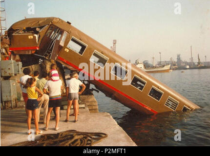 . Italiano: Incidente ferroviario al porto di Piombino del 31 luglio 1983: Il convoglio "Freccia dell'Elba' in Marcia verso La Stazione di Piombino Marittima, nell'approssimarsi Eine quest'ultima nicht riesce ad attuare correttamente Le operazioni di frenatura, impatta, col terminale posto sul Molo al Termine dei binari, lo abbatte e Schließen la propria Corsa in Mare. L'elettromotrice di Testa ALe 840 ne risultò immersa completamente, Seguita dalla rimorchiata Le 800.005 che si Tauchen anch'essa parzialmente in Acqua, rimanendo in bilico sul Bordo del Molo; il Resto del convoglio, Composto da un'al Stockfoto