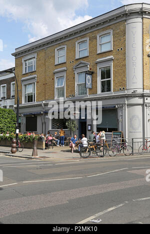 Das Victoria Inn auf der Bellenden Peckham Road, London. An einem Sommerabend mit Kunden von außerhalb in der Sonne sitzend dargestellt. Stockfoto