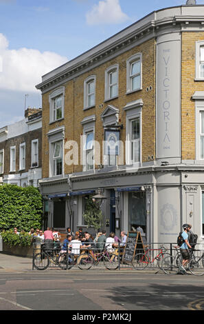 Das Victoria Inn auf der Bellenden Peckham Road, London. An einem Sommerabend mit Kunden von außerhalb in der Sonne sitzend dargestellt. Stockfoto