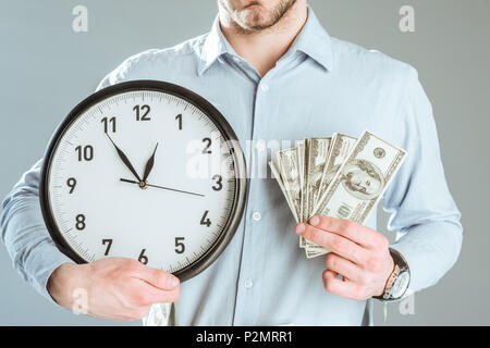Nahaufnahme der Geschäftsmann mit Geld und Uhr isoliert auf Grau Stockfoto