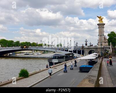 Menschen reiten Segways auf einer Tour, Parc Berges de Seine neben der Pont Alexandre III Bridge, Paris, Frankreich. Stockfoto