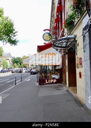 Paar Essen, durch das Fenster der Brasserie Lipp in der 6. Arrondissement, Saint-Germain, Paris, Frankreich gesehen. Stockfoto