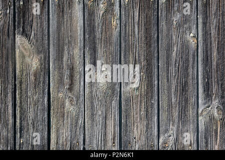 Hintergrundbild: das Fragment einer alten Mauer, mit Holzpaneelen mit ausgeprägter Struktur von Holz bedeckt. Stockfoto