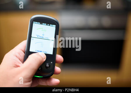 Mann mit einem inländischen Energy Smart Meter Einheit in der Küche und zeigt Ihren Energieverbrauch in Echtzeit Stockfoto