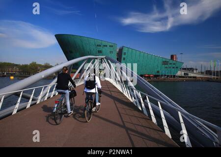 Niederlande, Provinz Nord Holland, Amsterdam, zwei Radfahrer auf der Brücke vor dem NEMO Museum des Architekten Renzo Piano Stockfoto