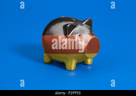 Piggy Bank mit deutscher Flagge auf blauem Hintergrund Stockfoto