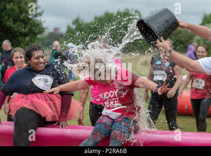 Poole, Großbritannien. 16 Juni, 2018. Eine junge Dame bekommt einen Eimer Wasser über den Kopf als Teil in der unordentlichen Rennen für das Leben recht schlammig Spendenlauf bei Baiter in Poole, Dorset, Großbritannien. Kredit Thomas Faull/Alamy Leben Nachrichten. Stockfoto