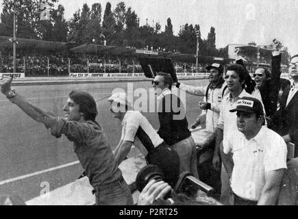 . Italiano: Monza, Autodromo Nazionale, 7 Settembre 1975. XLVI Gran Premio d'Italia. Il box della Scuderia Ferrari, a pochi Giri dal Termine, incita dal Muretto il suo Pilota, lo svizzero Clay Regazzoni, in Testa alla Corsa; si riconosce (a sinistra) il Team Manager della Scuderia, Luca Cordero di Montezemolo. "Cinquantesimo Giro, Regazzoni sbuca dalla Parabolica, ed Ich cartelli Sono ormai superflui. Dal box Ferrari si alzano Le braccia in Segno di Vittoria, il gesto di Luca Montezemolo è eloquente.". 7. September 1975. Unbekannt 2 1975 GP Italien - Ferrari box freut sich Stockfoto