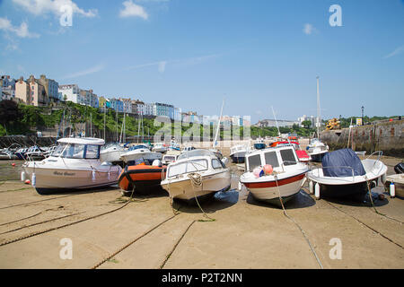 Tenby, Großbritannien: 11. Juni 2018: Boote im Hafen von Tenby bei Ebbe vertäut. Der Hafen ist in eine Ecke in Hafen Strand unterhalb Burg Hügel gebaut. Stockfoto