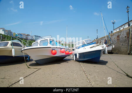 Tenby, Großbritannien: 11. Juni 2018: Boote im Hafen von Tenby bei Ebbe vertäut. Der Hafen ist in eine Ecke in Hafen Strand unterhalb Burg Hügel gebaut. Stockfoto