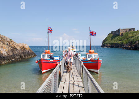 Tenby, Großbritannien: 11. Juni 2018: Tour Boote am Steg vertäut in Tenby bereit zu Insel Caldey zu segeln. Die Passagiere aussteigen nach dem Besuch der heiligen Insel. Stockfoto