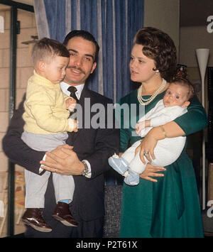 . König Hussein von Jordanien fotografierte in seinem Haus in Amman mit seinem ersten Sohn Abd Allah in den Armen, während seine Frau Muna hält ihren zweiten Sohn, feysal. Amman (Jordanien), März 1964. März 1964. Angelo Cozzi (Mondadori Verlag) 45 König Hussein und Prinzessin Muna mit Söhnen 1964 Stockfoto