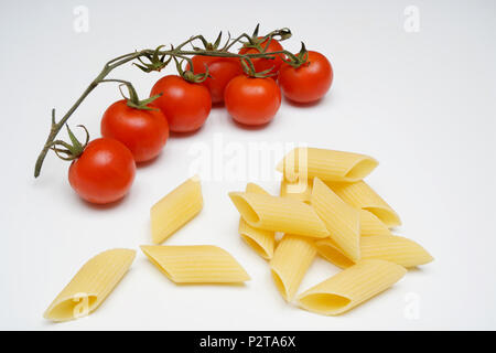 Ein Bündel von Tomaten und Nudeln auf einem weißen Tisch Stockfoto