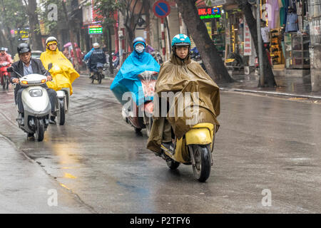 Motorräder und Fahrer an einem regnerischen Tag in Hanoi, Vietnam Stockfoto