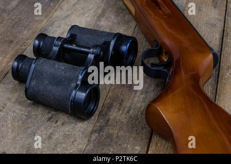 Schießen und pneumatische Waffe. Schild und Hits mit Blei Kugeln auf einem Holztisch. Der dunkle Hintergrund. Stockfoto