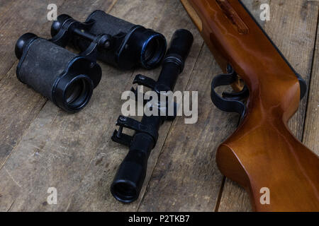 Schießen und pneumatische Waffe. Schild und Hits mit Blei Kugeln auf einem Holztisch. Der dunkle Hintergrund. Stockfoto
