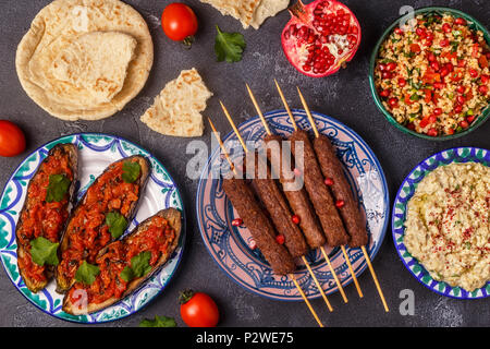 Klassische Kebabs, tabbouleh Salat, Baba ganush und gebackene Auberginen mit Soße. Traditionelle orientalische oder arabische Gericht. Ansicht von oben. Stockfoto