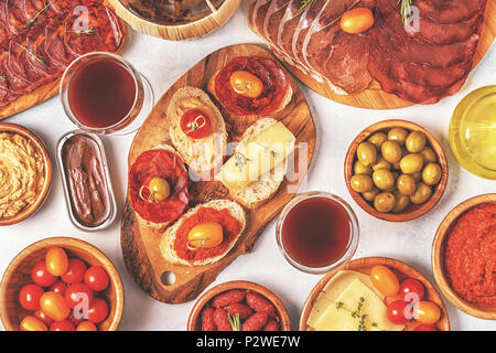 Typische spanische Tapas Konzept. Konzept gehören Scheiben Schinken, Chorizo, Wurst, Schüsseln mit Oliven, Tomaten, Sardellen, pürierte Kichererbsen, Käse. Stockfoto