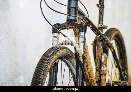 Dirty Mountainbike Federgabel Nach dem Reiten bei schlechtem Wetter. Schmutz und Öl Flecken an den Beinen der Mountainbike Gabel Stockfoto