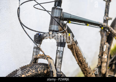 Dirty Mountainbike Federgabel Nach dem Reiten bei schlechtem Wetter. Schmutz und Öl Flecken an den Beinen der Mountainbike Gabel Stockfoto