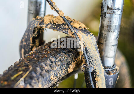 Dirty Mountainbike Federgabel Nach dem Reiten bei schlechtem Wetter. Schmutz und Öl Flecken an den Beinen der Mountainbike Gabel Stockfoto