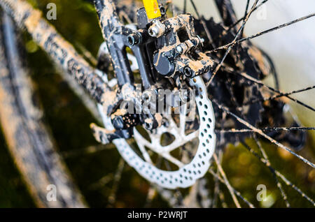 Läufer von Hinten hydraulische Bremse auf dem Mountainbike. Schmutz auf Mountainbike Rahmen nach dem Rennen bei schlechtem Wetter Stockfoto